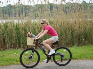 Girl on bike dog in basket